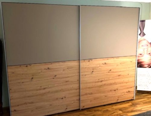 Zweiseitige Schwebetürenschrnk mit mittig geteilten Türfronten grauer Türoberfläche oben und unten Holzdekor. Breite 280cm, Höhe 223 cm