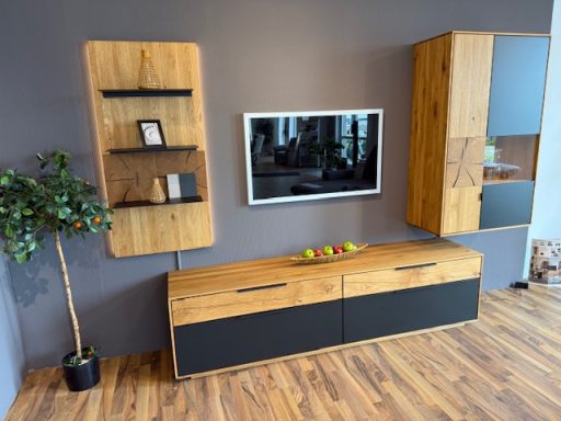 Wohnwand Eiche massiv mit dunklen Glasaplikationen, Holzregalen, TV Unterteil und schmalem Holzhänger